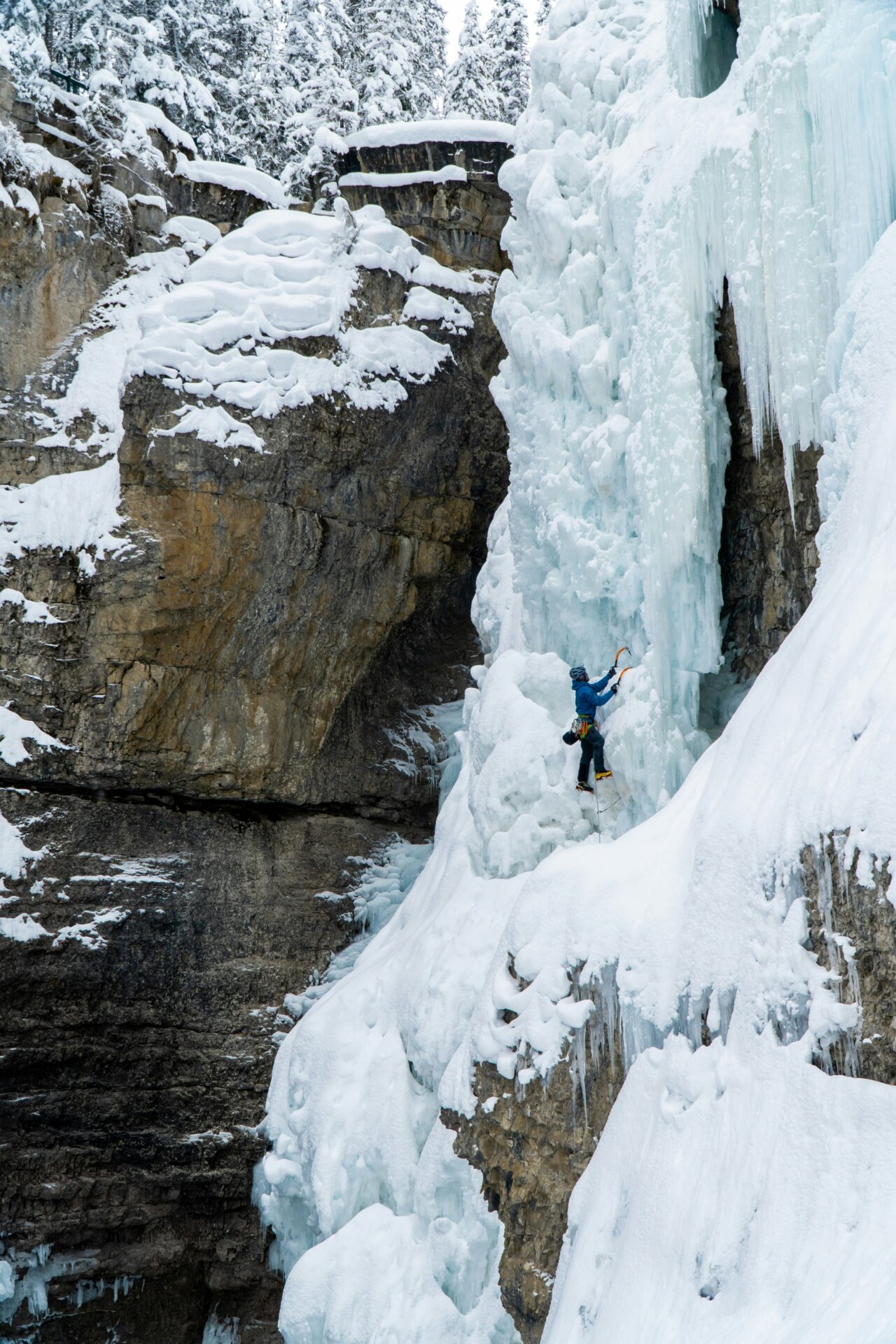 un sportif qui grimpe une cascade de glace